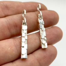 Load image into Gallery viewer, Rectangular earring dangles with bubble-like raised texture, held flat on fingers
