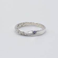Load image into Gallery viewer, Textured twist ring shown on a flat white surface, diagonal sideview.

