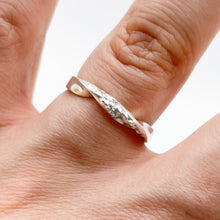 Load image into Gallery viewer, Silver twist ring shown on a finger, showing that it is the same width all the way around.
