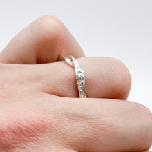 Load image into Gallery viewer, twist ring on a finger, showing the low profile of the twist.
